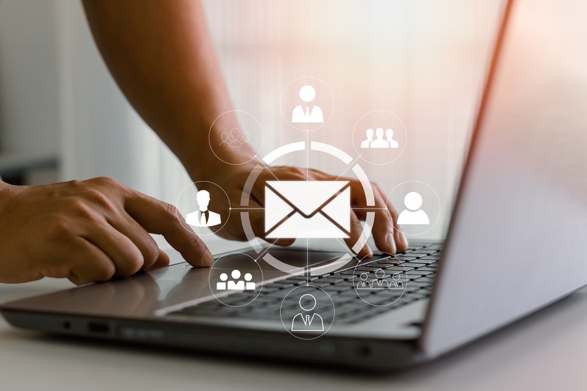 User on laptop with icons for email and social media to represent common social engineering risks